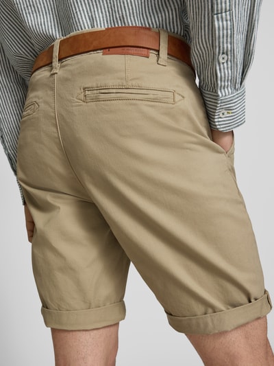 Männermodel trägt Shorts mit Gürtel Modell 'MIKE' von Redefined Rebel in Beige, strukturierter Baumwollstoff, Gesäßtaschen, Ganzkörperansicht Rückansicht.