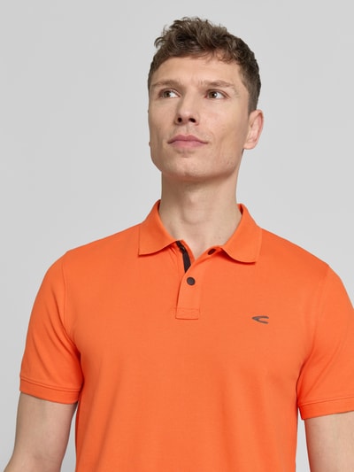 Męski model nosi Regular Fit Poloshirt in unifarbenem Design von camel active, mieszanka bawełny i elastanu, logo, listwa guzikowa, krój regular fit, jednokolorowy, długość tyłu w rozmiarze M: 70 cm, zbliżenie na górną część ciała z przodu.