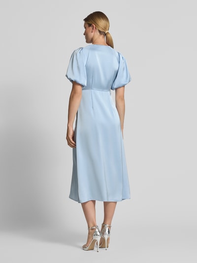 Frauenmodel trägt Midikleid aus Satin Modell 'Illana' von Neo Noir in Hellblau mit taillierter Passform, Rückansicht, Ganzkörperansicht. Elastischer Material-Mix, kurze Ärmel, leichte Raffungen, matter Glanz, Rückenlänge 122 cm, Brustweite 40 cm, Ärmellänge 33 cm.