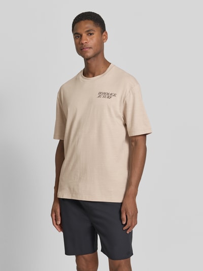 Mannenmodel draagt Regular Fit T-shirt aus Baumwoll-Mix van s.Oliver RED LABEL, look: effen kleuren, opschrift-applicatie, ronde hals, korte mouw, jerseymateriaal, katoenmix. Ganzkörperansicht van voren.