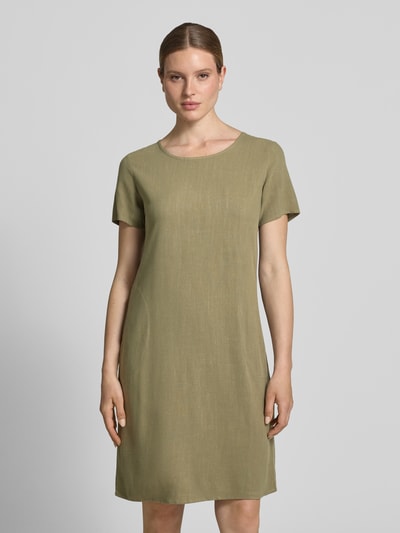 Frauenmodel trägt Relaxed Fit Kleid aus Viskose-Mix Modell 'Tara' von ZABAIONE in Olivgrün, Kurzärmelig, Ganzkörperansicht von vorne, Leinen-Viskose-Anteil, Rundhalsausschnitt, Rückenlänge 96 cm, Brustweite 49 cm, Ärmellänge 21 cm.