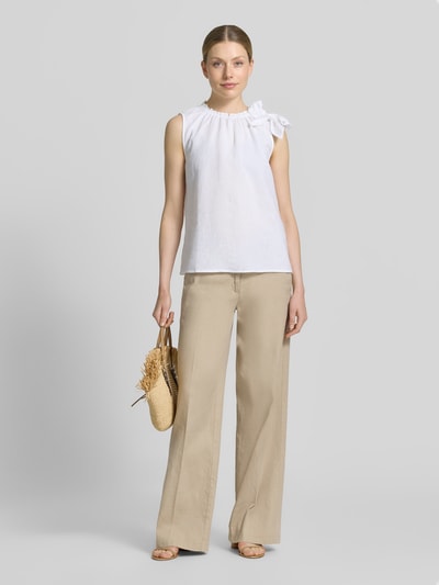 Frauenmodel trägt Regular Fit Bluse aus Viskose-Mix mit Leinen-Anteil von Christian Berg Woman, Zierschleife, Stehkragen mit Rüschenbesatz, Ärmelloses-Design, Rückenlänge 54 cm bei Größe 36, helle Farbtöne, glatte Textur, Ganzkörperansicht von vorne.