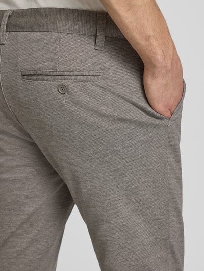 Mężczyzna nosi Slim Fit Chino aus Viskose-Mix Modell 'MARK' von Only & Sons, drobno tkany materiał, wzór w kratkę, neutralny kolor, detal tylnej kieszeni, krój slim fit, label, widok z tyłu, zbliżenie na biodro
