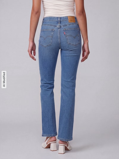 Frauenmodel trägt Slim Fit Bootcut-Jeans aus Baumwoll-Mix mit Lyocell-Anteil Modell '725 HIGH RISE BOOTCUT' von Levi's® 300 in Hellblau, Ganzkörperansicht Rückansicht, Damen Bootcut-Jeans von Levi's® 300, KI-modifiziertes Bild.