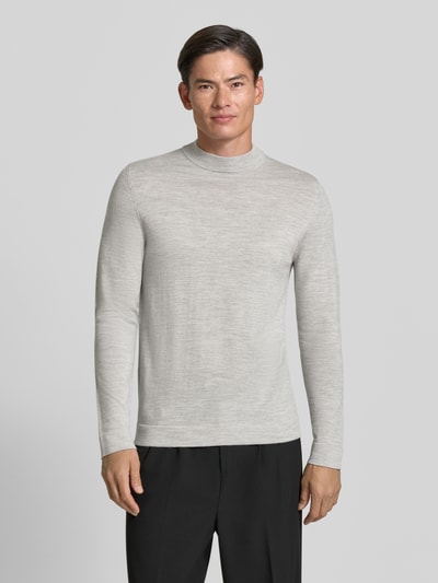 Männermodel trägt Slim Fit Longsleeve aus reiner Schurwolle Modell 'Arwon' von DRYKORN, hellgrau, glatte Struktur, Ganzkörperansicht von vorne. Rückenlänge 67 cm, Ärmellänge 68 cm, Stehkragen.
