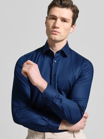 Männermodel trägt Slim Fit Business-Hemd mit Strukturmuster und Kentkragen von OLYMP, einfarbig dunkelblau, Baumwoll-Mix, Nahaufnahme Oberkörper.