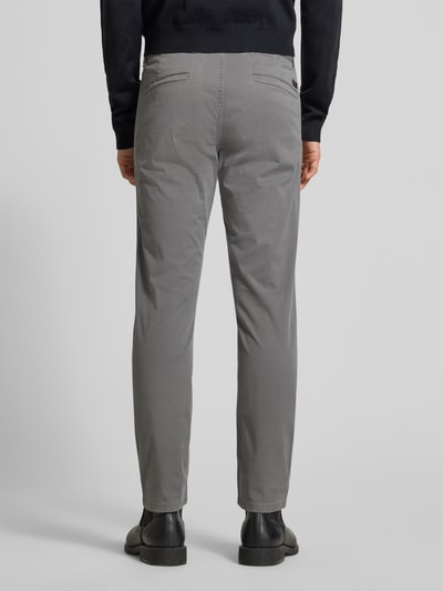 Męskimodel nosi Slim Fit Chinosy aus Baumwoll-Mix Model 'CHINO_SLIM' von BOSS, szary kolor, fakturowany wzór na całej powierzchni, naszywka z logo, wpuszczane kieszenie, mieszanka bawełny, całkowita tylna perspektywa.