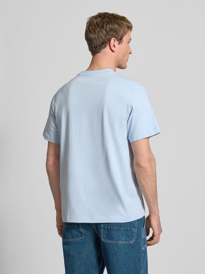 Männermodel trägt T-Shirt mit Label-Print und Rundhalsausschnitt von Calvin Klein Jeans in Hellblau, reine Baumwolle, Regular-Fit, Ganzkörperansicht Rückansicht.