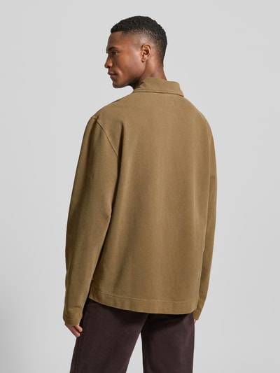 Męski model nosi Loose Fit Poloshirt aus Baumwolle Modell 'Thiago' od Wood Wood w kolorze brązowym, czysta bawełna, długość tyłu 71 cm w rozmiarze M, widok całej sylwetki z tyłu.