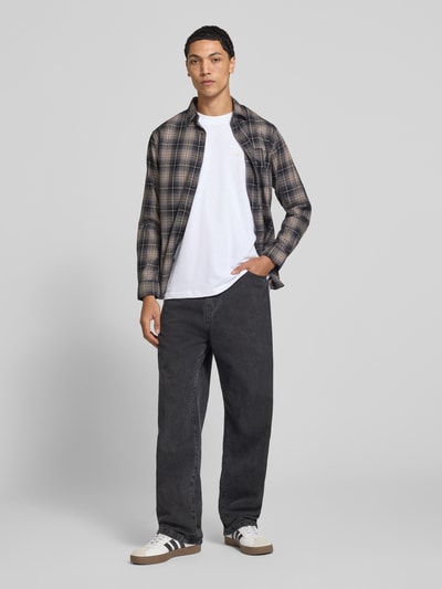 Männermodel trägt Slim Fit Freizeithemd aus reiner Baumwolle Modell 'James' von JACK & JONES in kariertem Muster, Ganzkörperansicht von vorne. Kontext: Herren Freizeithemd, Brusttasche, langärmelig, Kentkragen, Rückenlänge 75 cm, Schulterbreite 48 cm, Ärmellänge 66 cm.