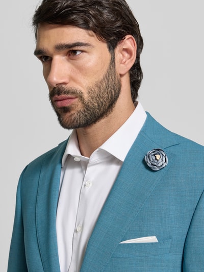 Männermodel trägt Slim Fit 2-Knopf-Sakko aus Viskose-Mix von Carl Gross in Blau mit floraler Zier-Applikation, Strukturmuster, Nahaufnahme Oberkörper.