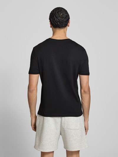 Männermodel trägt Basic Slim Fit T-Shirt mit Flock-Logo auf der Brust von REVIEW aus Baumwoll-Viskose-Mix in Schwarz, Ganzkörperansicht Rückansicht.