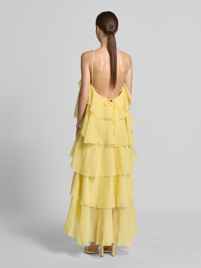 Frauenmodel trägt Maxikleid mit 3D-Rüschendetails Modell 'Delilah' von Vero Moda in Unifarbe Gelb, Neckholder, Maxi-Länge, Ganzkörperansicht Rückansicht.