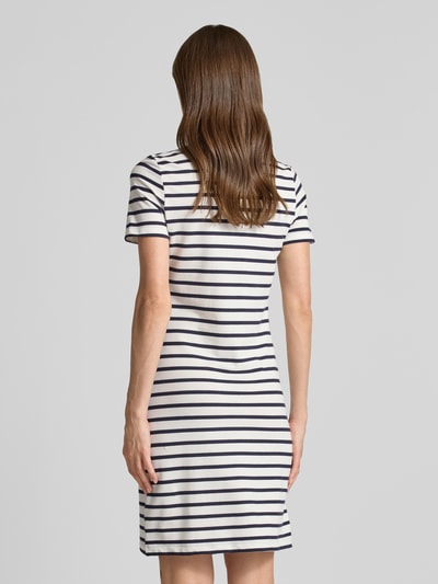 Frauenmodel trägt knielanges Polokleid mit kurzer Knopfleiste von Gant, weiß mit dunkelblauen Streifen, Baumwoll-Mix, Ganzkörperansicht Rückansicht.
