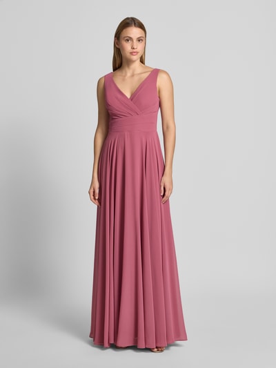 Frauenmodel trägt Maxikleid aus Chiffon in Wickel-Optik von TROYDEN COLLECTION in A-Linie, altrosa, fließende Textur, Ganzkörperansicht von vorne.