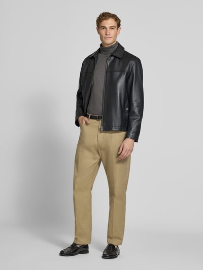 Männermodel trägt Regular Fit Rollkragenpullover aus reiner Baumwolle von Polo Ralph Lauren in Grau, kombiniert mit heller Hose, Ganzkörperansicht von vorne.