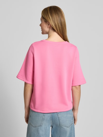 Frauenmodel trägt T-Shirt mit Statement-Stitching von Milano Italy im Material-Mix mit Baumwoll-Anteil, Relaxed-Fit, Rückenlänge 56 cm, Rundhalsausschnitt, einfarbig pink mit glatter Textur, Ganzkörperansicht Rückansicht.