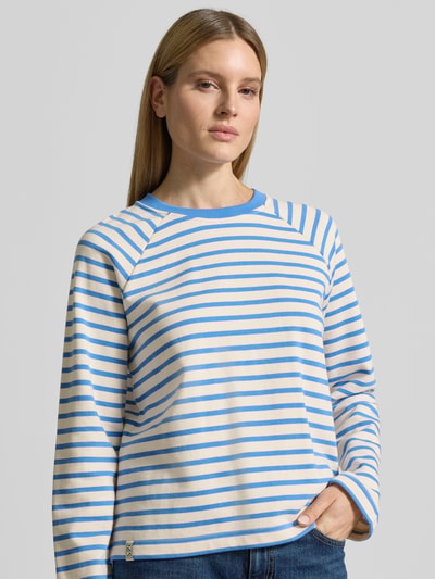 Frauenmodel trägt Sweatshirt mit Raglanärmeln Modell 'Lidy' von MOS MOSH aus Reine Baumwolle, Lockerer-Schnitt, Rundhalsausschnitt, gestreift in Blau und Creme, strukturierte Oberfläche, Ganzkörperansicht von vorne.