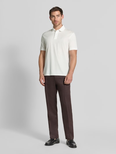 Männermodel trägt Slim Fit Poloshirt mit Logo-Stitching von Emporio Armani in Weiß, Lyocell-Mix, Polokragen, Ganzkörperansicht von vorne.