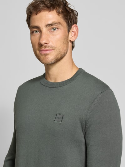 Männermodel trägt Regular Fit Pullover aus Baumwoll-Kaschmir-Mix Modell 'Kanovano_S' von BOSS, dezentes Grau, Strukturstrick, Herren Pullover von BOSS Orange, Nahaufnahme Oberkörper.