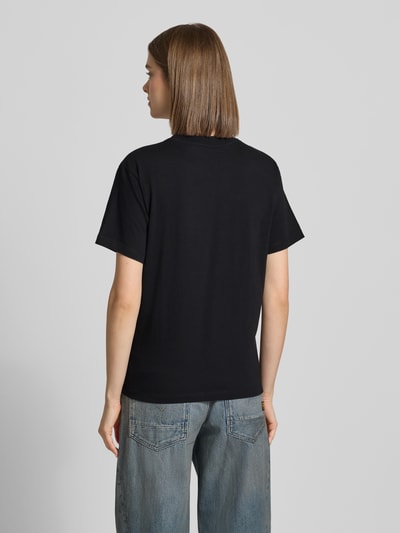 Kobiece model nosi damski t-shirt z bawełny o prostym kroju i okrągłym dekolcie marki Carhartt Work In Progress, długość tyłu w rozmiarze S: 58 cm, widok całej sylwetki z tyłu.
