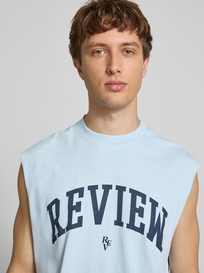 Männermodel trägt Tanktop mit Logo-Print von REVIEW in Hellblau mit Rundhalsausschnitt, Reine Baumwolle, Gerader-Schnitt, Nahaufnahme Oberkörper.