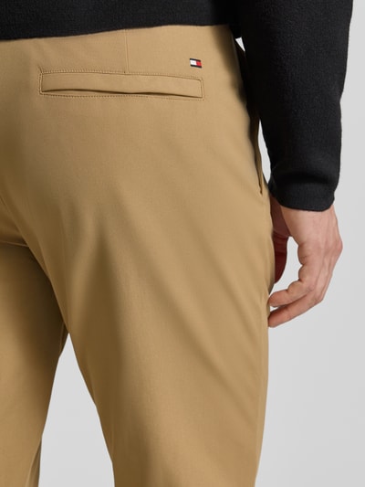 Männermodel draagt Straight Leg Broek uit ademend materiaal Model 'Denton' van Tommy Hilfiger, effen look, detailopname achterkant.