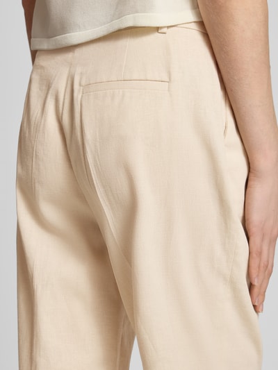 Vrouwenmodel draagt Straight Fit Stoffhose aus Leinen-Mix van Christian Berg Woman Selection in lichtbeige, elastische linnenmix, biesplooien, achterzak, detailopname rug.