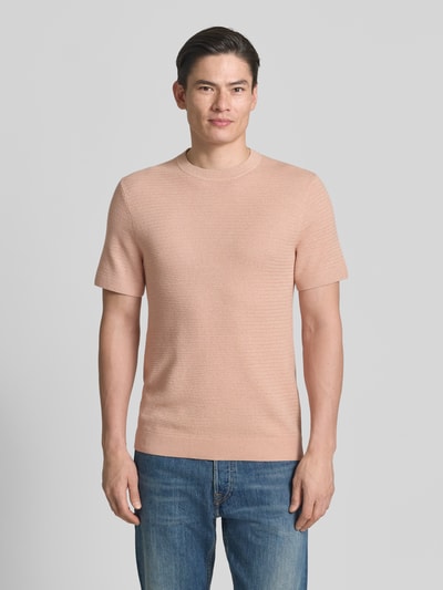 Männermodel trägt Strickshirt mit Rundhalsausschnitt Modell 'RILEY' von Jack & Jones Premium, Reine Baumwolle, Slim-Fit, Strukturmuster, Ganzkörperansicht von vorne.
