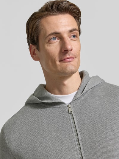 Männermodel trägt Regular Fit Pullover aus reiner Baumwolle von Marc O'Polo in Hellgrau mit feiner Struktur, Nahaufnahme Oberkörper.