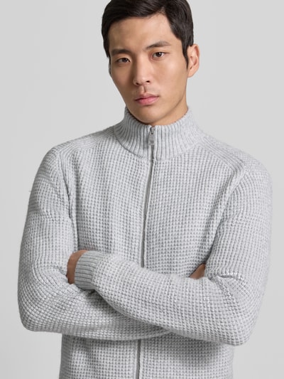 Männermodel trägt Regular Fit Strickjacke mit Woll-Anteil von Tom Tailor in melierter Optik, Silbergrau, Reißverschluss, Nahaufnahme Oberkörper.
