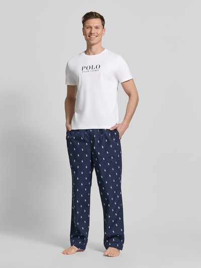 Männermodel trägt Regular Fit Pyjama-Oberteil aus reiner Baumwolle Modell 'CREW-SLEEP-TOP' von Polo Ralph Lauren Underwear, Optik: Unifarben, Passform: Regular-Fit, Kurzarm, mit Logo-Stitching und Label Print, Crew Neck, in Weiß; Ganzkörperansicht von vorne.