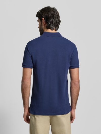 Männermodel trägt Shaped Fit Poloshirt aus reiner Baumwolle von Polo Ralph Lauren in effen blauw, piqué structuur, logo-stitching, kort mouw, polokraag, katoenen materiaal, shaped fit, zakelijk. Ganzkörperansicht Rückansicht.