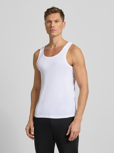 Männermodel trägt Tanktop mit Label-Print Modell 'Tank Top Original' von BOSS aus reiner Baumwolle im eng anliegenden Schnitt, Unifarbenes-Design, Ripp-Optik, Rundhalsausschnitt und breiten Trägern, Ganzkörperansicht von vorne.