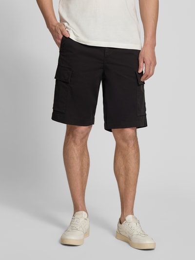 Männermodel trägt Relaxed Fit Cargoshorts aus Baumwoll-Mix Modell 'SISLA' von BOSS Orange, unifarben, schwarze Textur, Nahaufnahme Oberschenkel.