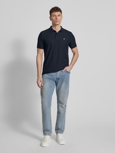 Męski model nosi Regular Fit Poloshirt mit Logo-Stitching Modell 'Performance' od Lerros, bawełniany miks, krój regular fit, krótki rękaw, kolor granatowy, widoczny haft logo, długość pleców 72 cm w rozmiarze M, zdjęcie całej sylwetki z przodu.