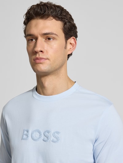 Mężczyznę model nosi Regular Fit T-Shirt aus reiner Baumwolle Modell 'TS_TERRACE' von BOSS Green, krój regular fit, jersey, niebieski, unikatowy 3D-Label Print, okrągły dekolt, krótki rękaw, z przodu, zbliżenie na górę ciała.