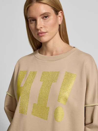 Kobiece modelka nosi Oversized Sweatshirt mit Label-Detail von miss goodlife, bawełna, krój oversized, prążkowane wykończenia, okrągły dekolt, detal z logo, zbliżenie na górną część ciała