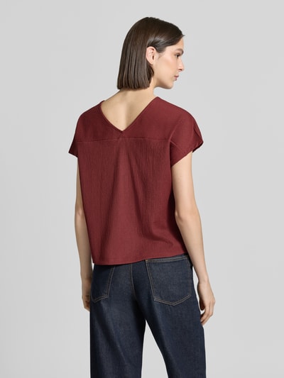 Frauenmodel trägt Relaxed Fit T-Shirt mit Allover-Muster von s.Oliver RED LABEL in dunklem Rot, strukturierter Jersey, Ganzkörperansicht Rückansicht.