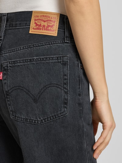Kobiece model prezentuje czarne Loose Fit Jeans z kieszeniami, model 'MIDDY LOOSE BOOT' od Levi's®, detal tylnej kieszeni, z czystej bawełny, zbliżenie na biodra.