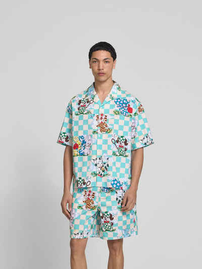 Männermodel trägt Freizeithemd mit Allover-Motiv-Print von Kenzo in Türkis-Weiß mit buntem Print, Reverskragen, Relaxed-Fit, Reine Baumwolle, Ganzkörperansicht von vorne.