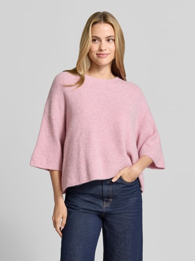 Vrouwenmodel draagt Oversized Strickpullover mit Leinen-Anteil van American Vintage, Materiaalmix met linnen, oversized fit, ronde hals, geribd, halflange mouwen, ruglengte 50 cm, mouwlengte 54 cm, zachtroze kleur, Ganzkörperansicht van voren.
