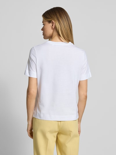 Männermodel trägt T-Shirt mit Motiv-Print und Strasssteinbesatz von Rich & Royal aus bawełna ekologiczna, krój straight fit, okrągły dekolt, długość tyłu w rozmiarze S: 58 cm, widok całej sylwetki z tyłu
