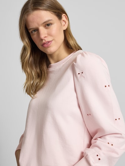 Frauenmodel trägt Regular Fit Sweatshirt aus Baumwoll-Mix Modell 'FEMME' von Only, Optik: Unifarben, Lochstickdetails, Ballonärmel, Crew Neck, Materialverarbeitung: Sweat, Farbe Hellrosa, Nahaufnahme Oberkörper.