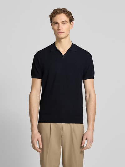 Männermodel trägt Regular Fit Poloshirt aus Lyocell-Mix mit Seiden-Anteil von Profuomo, Strukturmuster, V-Ausschnitt, schwarz, Ganzkörperansicht von vorne.