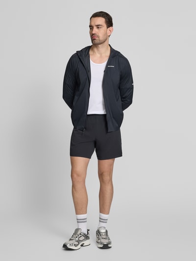 Męski model trägt szorty z elastycznym pasem od Salomon, mieszanka materiałów z dodatkiem streczu, krój regular fit, logo, czarne, szerokość w rozmiarze M 38 cm, długość wewnętrzna nogawki 16 cm, ganzkörperansicht von vorne.