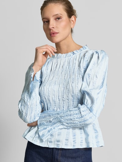 Frauenmodel trägt hellblaue Bluse in tailliertem Schnitt mit Smok-Details Modell 'RAVA' von YAS, Viskose-Mix, Nahaufnahme Oberkörper.