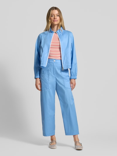 Frauenmodel trägt Wide Fit Stoffhose mit aufgesetzten Taschen von Marc Cain, hellblau, verkürzte Passform, elastischer Baumwoll-Mix, Ganzkörperansicht von vorne.
