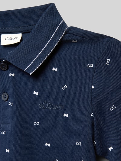 Junge trägt Regular Fit Poloshirt aus reiner Baumwolle von s.Oliver RED LABEL in Dunkelblau, Optik:Allover-Muster, Label-Stitching, Nahaufnahme Oberkörper.