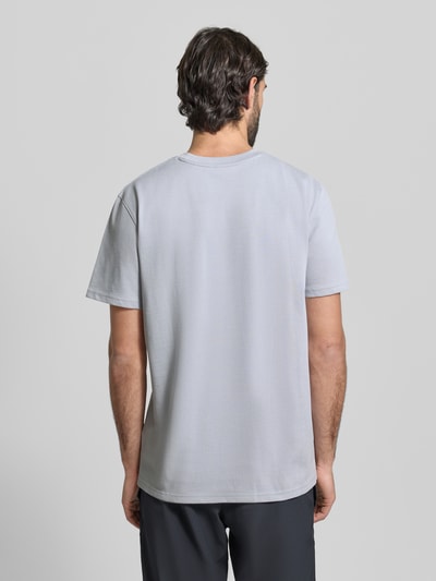 Męski model ma na sobie Regular Fit T-Shirt mit Logo-Applikation od Under Armour, bawełniany miks, krój regular fit, jasnoszary kolor, okrągły dekolt, długość pleców w rozmiarze M: 73 cm, tekstura gładka, całkowity widok z tyłu.